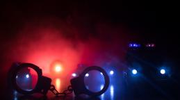 menottes fermées sur le trottoir de la rue la nuit avec des feux de voiture de police© zef art