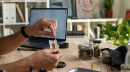 Personne qui roule un joint de cannabis sur son bureau. ©amenic181 | Adobe Stock
