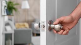 Une main d'un homme qui ouvre une porte de maison. © Pixel-Shot | Adobe Stock