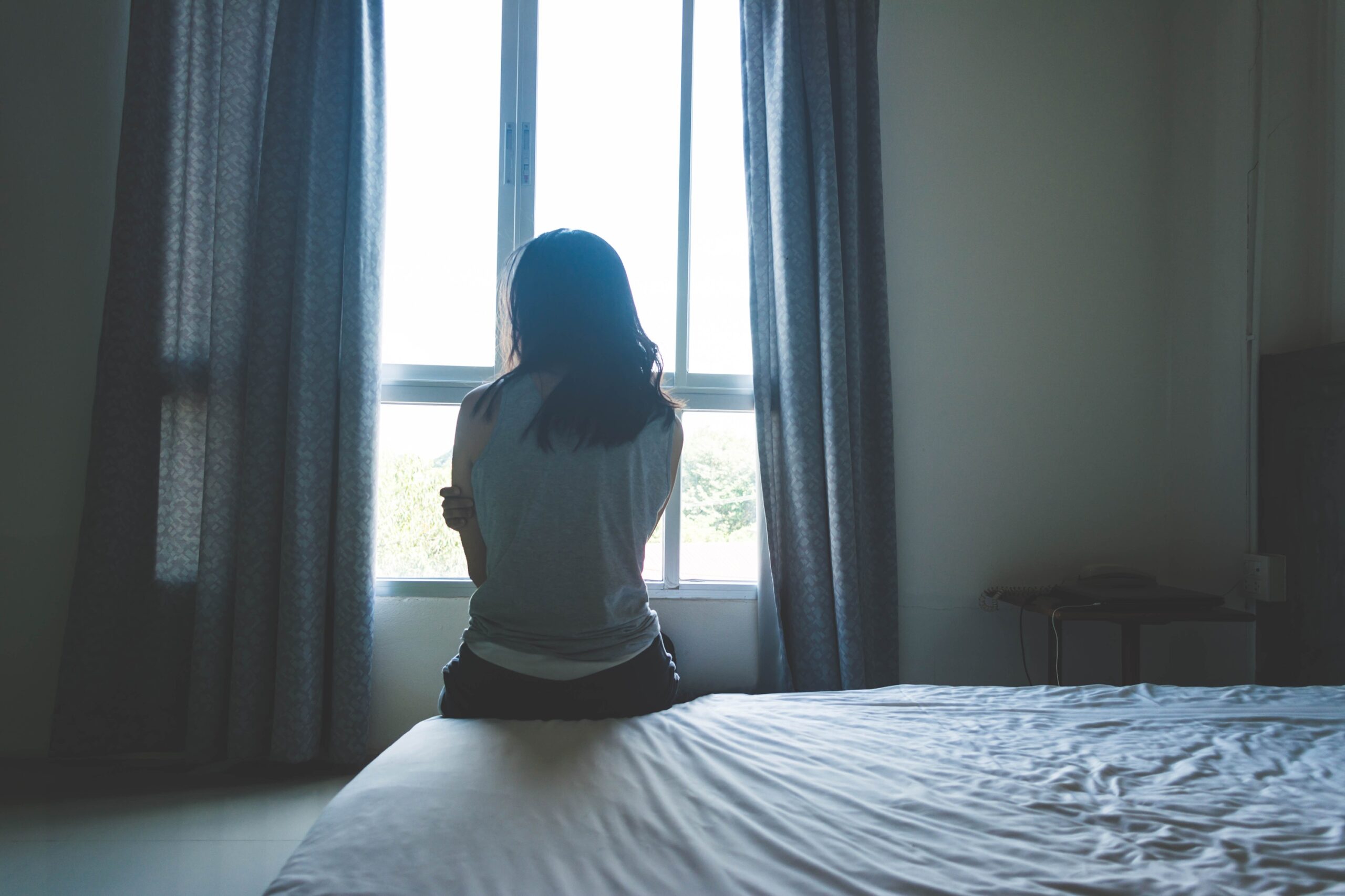 Adolescente assise sur un lit